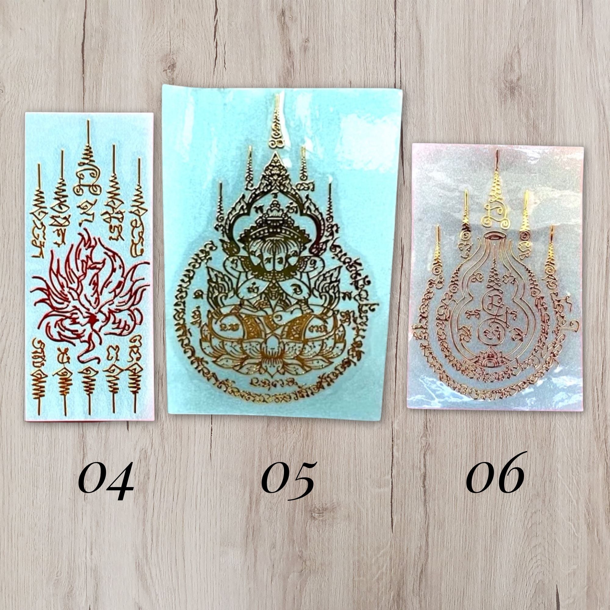 Three sheets of temporary tattoo stickers with Thai script and traditional designs, numbered 04, 05, and 06, displayed on a light wood background.