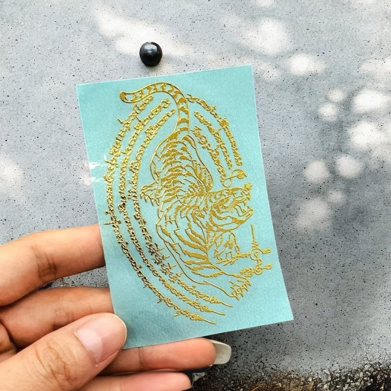 Yant Suea Liaw Lang Tiger Looking Back gold embossed Thai talisman sticker close-up